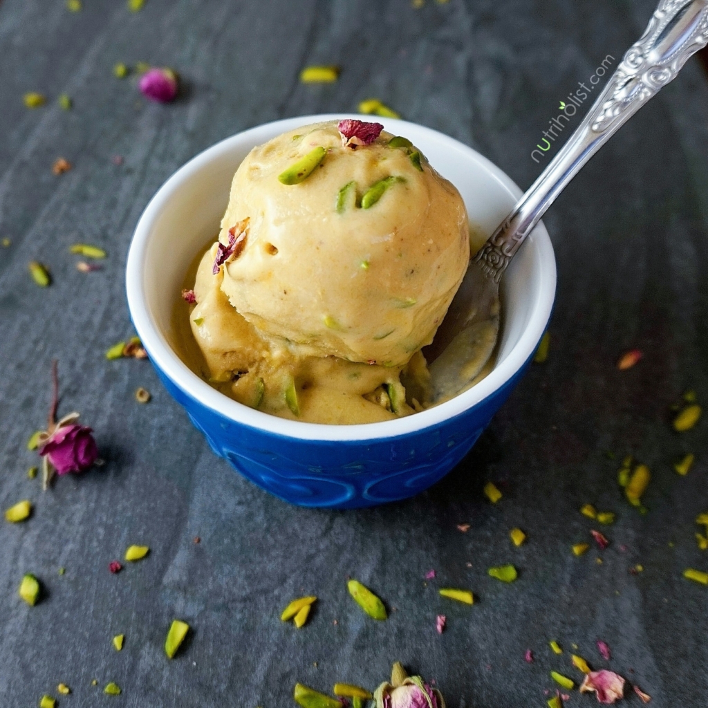A scoop of Vegan Persian Saffron Ice Cream topped with slivered pistachios and dried rose petals
