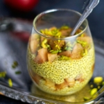 Saffron Rose Water Chia Pudding layered in a cup with warm apple compote topped with pistachios