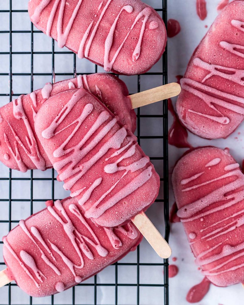 Strawberry Cheesecake Popsicles laid on top of each other on a cooling rack